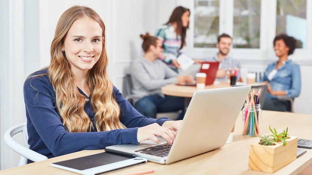 A female apprentice sitting at her laptop and studying for her apprenticeship.